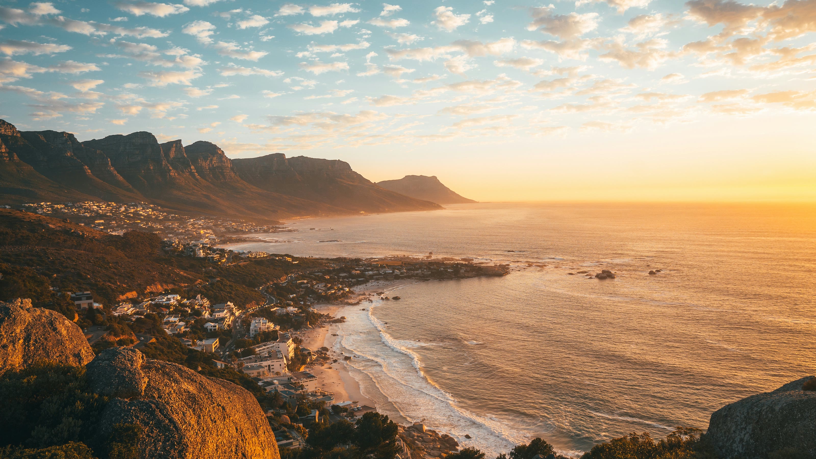 Camps Bay and the Twelve Apostles at golden hour, the sea stretching to the horizon