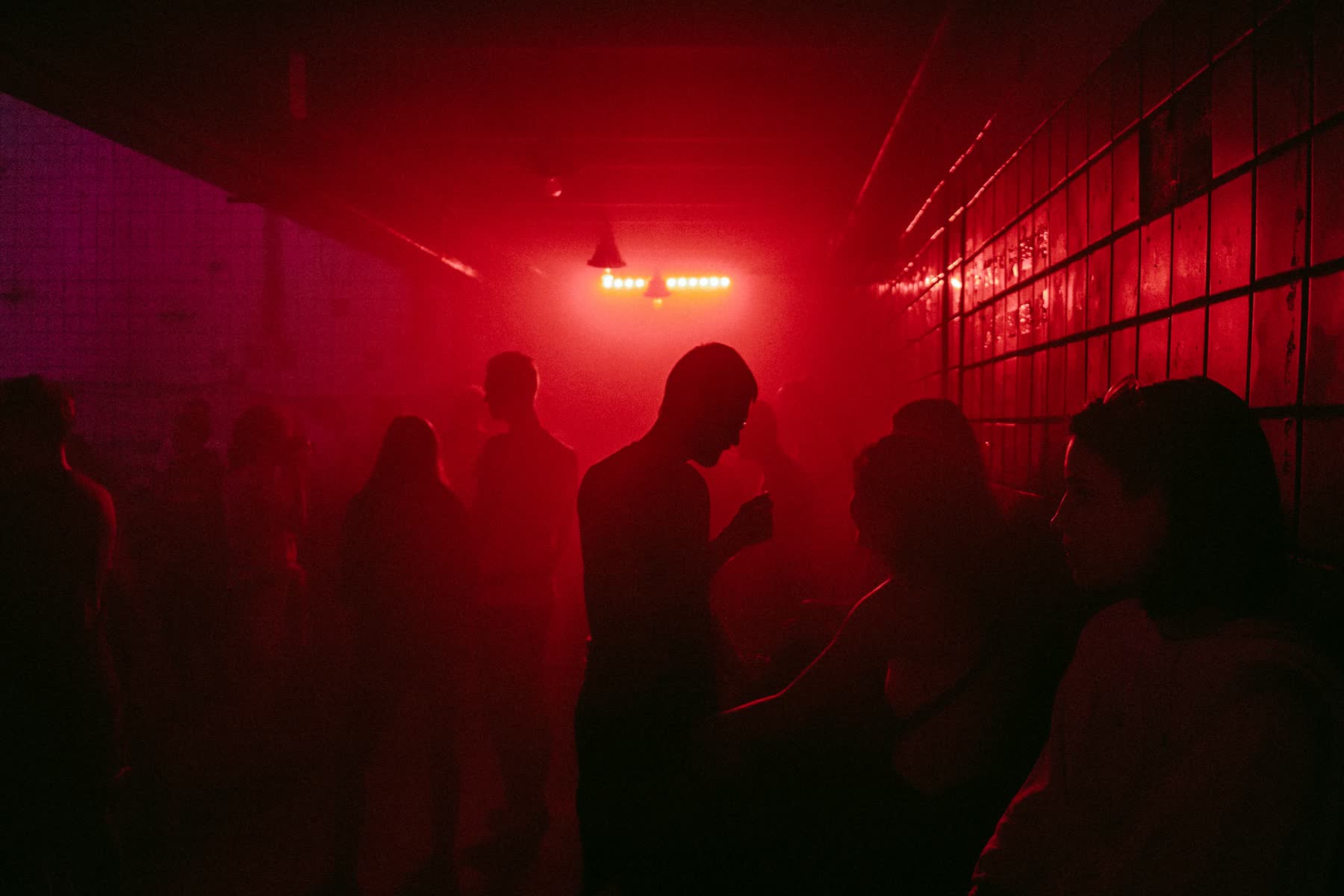 A crowd in a club lit red
