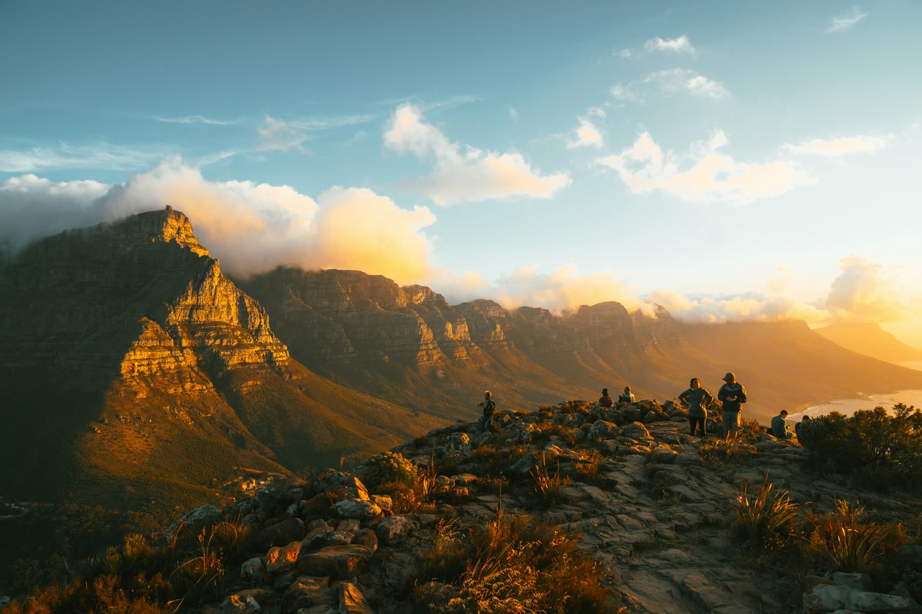 People watching the sunset from Lion's Head, with Table Mountain and the Twelve Apostles behind